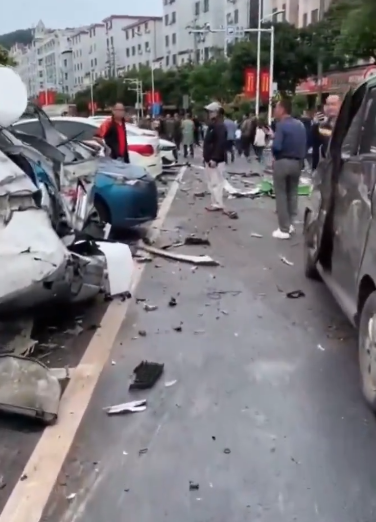 江西贛州一輛Tesla Model Y電動車行駛時,疑因緊急避讓行人操作不當,撞上道路設施和停在路邊的車輛,車輛凌空飛起,翻滾多圈砸壞路上約9輛車,造成4人受傷。(影片截圖)