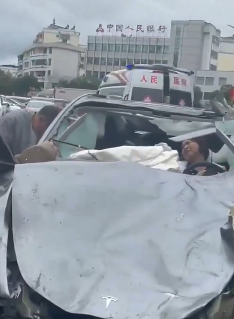 江西贛州一輛Tesla Model Y電動車行駛時,疑因緊急避讓行人操作不當,撞上道路設施和停在路邊的車輛,車輛凌空飛起,翻滾多圈砸壞路上約9輛車,造成4人受傷。(影片截圖)