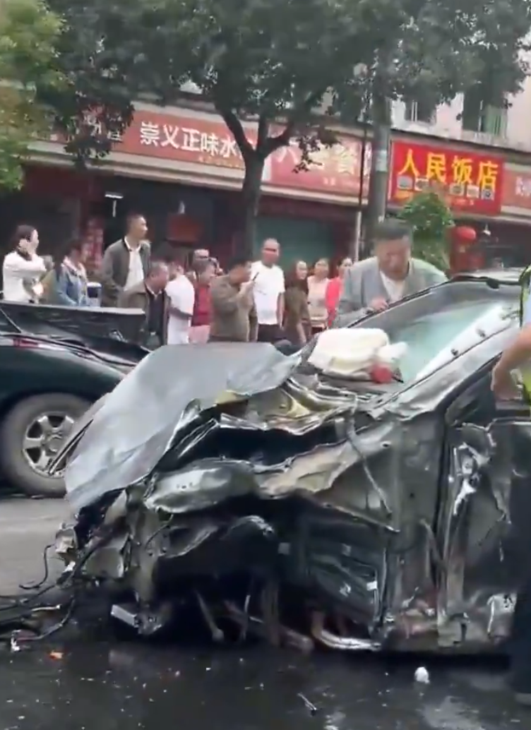 江西贛州一輛Tesla Model Y電動車行駛時,疑因緊急避讓行人操作不當,撞上道路設施和停在路邊的車輛,車輛凌空飛起,翻滾多圈砸壞路上約9輛車,造成4人受傷。(影片截圖)