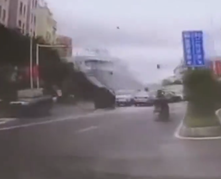 江西贛州一輛Tesla Model Y電動車行駛時,疑因緊急避讓行人操作不當,撞上道路設施和停在路邊的車輛,車輛凌空飛起,翻滾多圈砸壞路上約9輛車,造成4人受傷。(影片截圖)