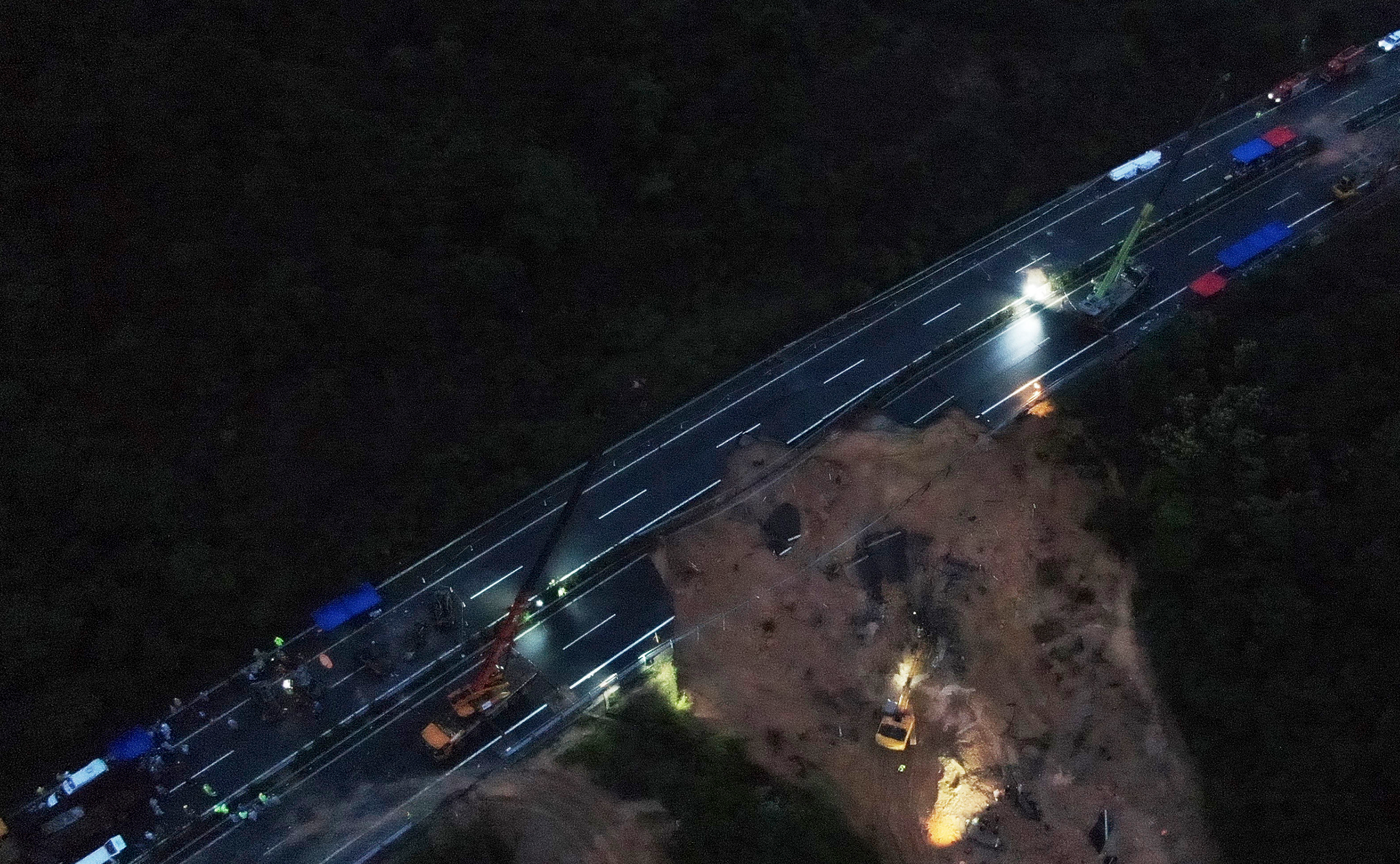 梅龍高速路陷|救援隊伍仍在路面陷落的大坑中通宵挖掘和搜救,爭取在72小時黃金時間內,營救可能受困的人。(新華社)