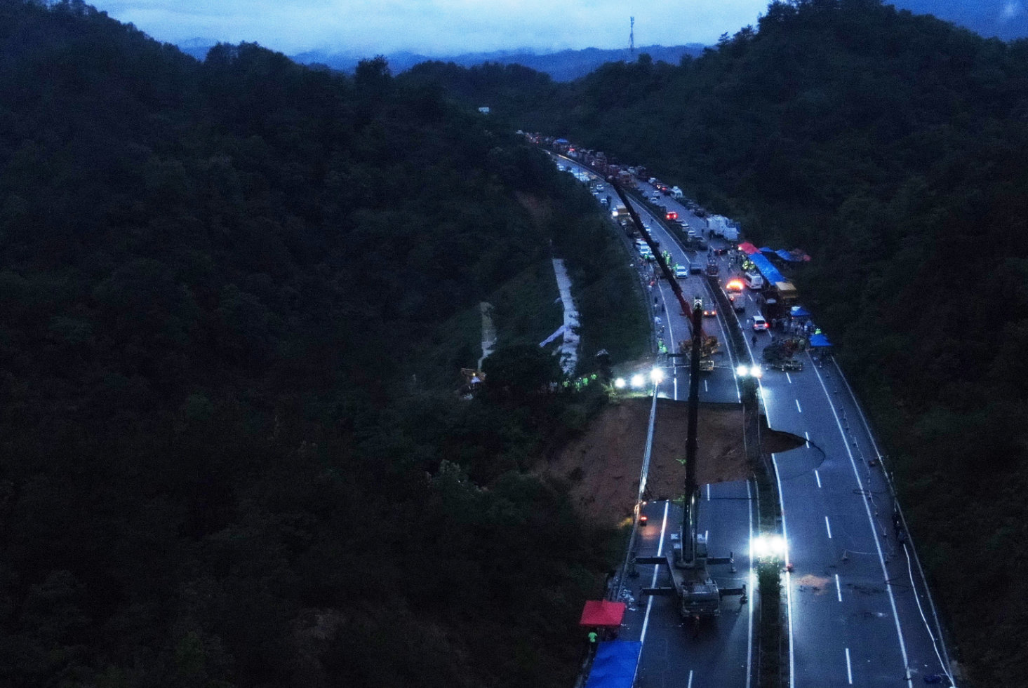 梅龍高速路陷|救援隊伍仍在路面陷落的大坑中通宵挖掘和搜救,爭取在72小時黃金時間內,營救可能受困的人。(新華社)