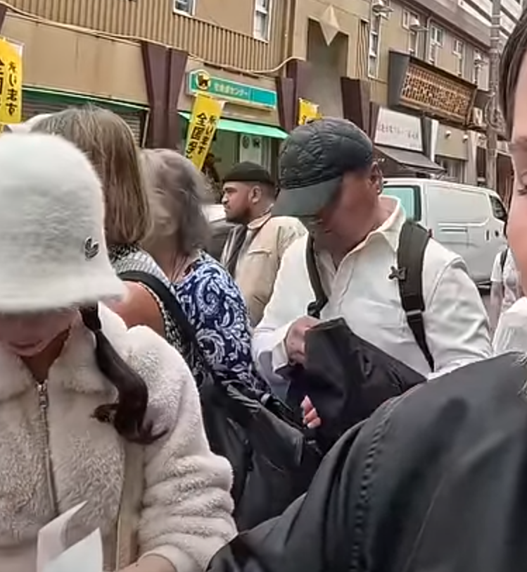 及後迅速將左手伸入其背囊,用外套掩護下取走皮包,短短3秒就成功得手,動作十分老練流暢