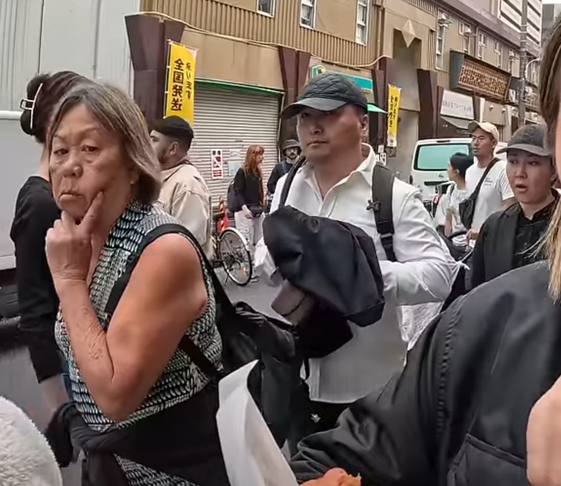 及後迅速將左手伸入其背囊,用外套掩護下取走皮包,短短3秒就成功得手,動作十分老練流暢