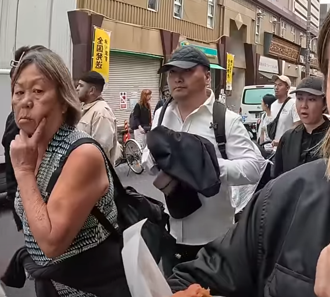 及後迅速將左手伸入其背囊,用外套掩護下取走皮包,短短3秒就成功得手,動作十分老練流暢