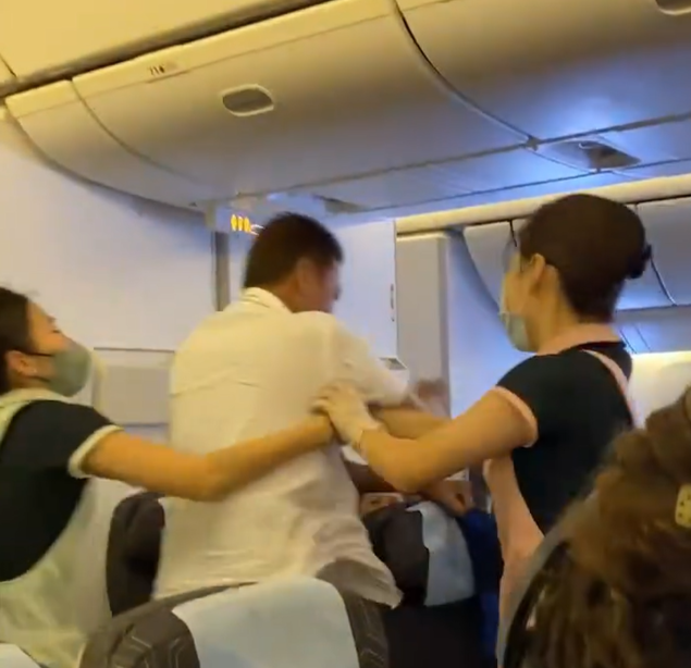 長榮航空一架由台北前往三藩市的航班發生乘客衝突事件,3名空姐力阻雙方互毆,一人更擋於二人之間幾乎中拳。(影片截圖)