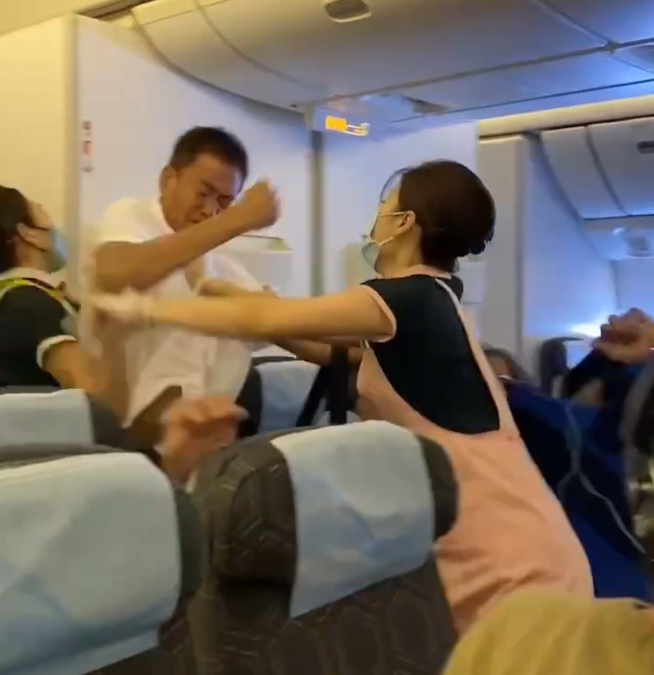 長榮航空一架由台北前往三藩市的航班發生乘客衝突事件,3名空姐力阻雙方互毆,一人更擋於二人之間幾乎中拳。(影片截圖)