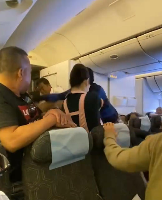 長榮航空一架由台北前往三藩市的航班發生乘客衝突事件,3名空姐力阻雙方互毆,一人更擋於二人之間幾乎中拳。(影片截圖)