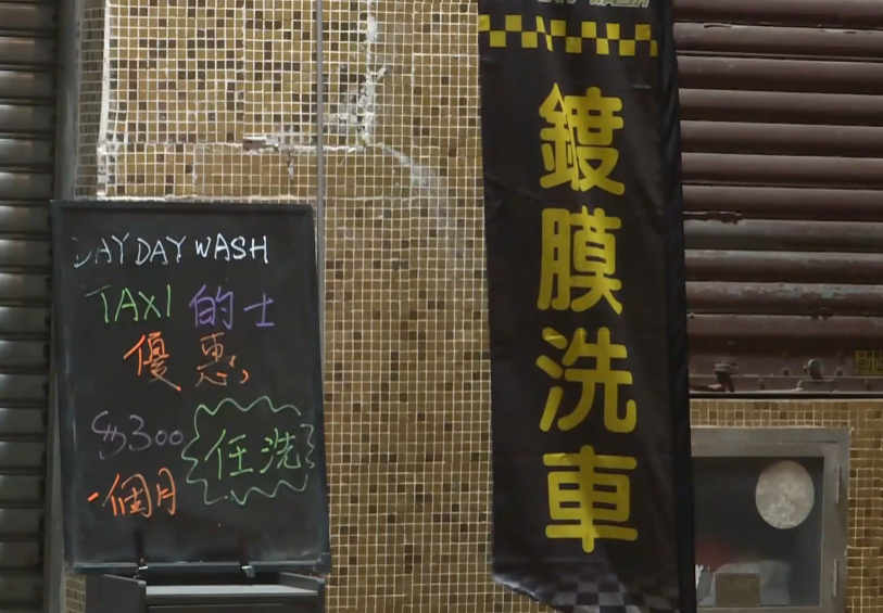 5名非華裔男子及3名本地男子手持木棍闖入德業街6至14號一間洗車店破壞。(有線新聞畫面)