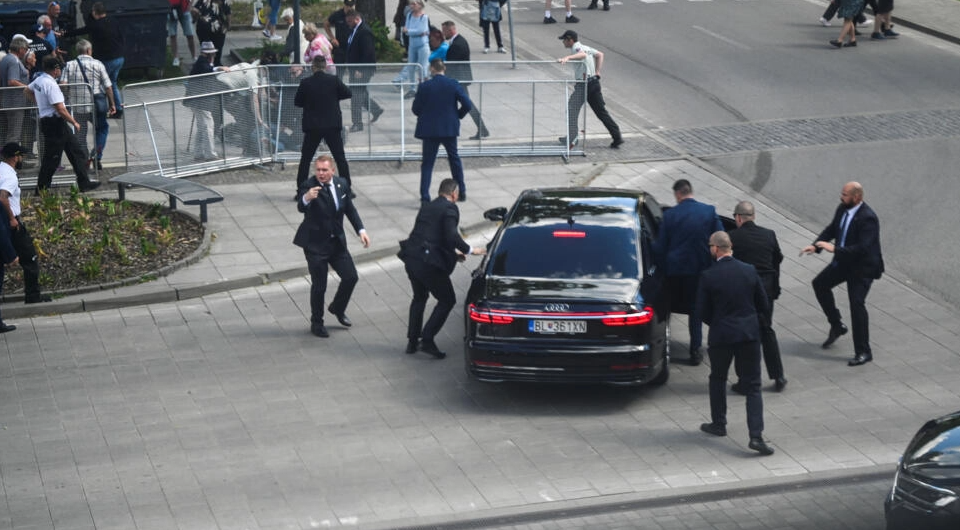 菲佐中槍後由保鑣護送上車。(路透社)