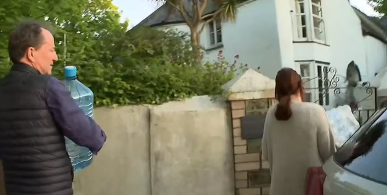 居民把樽裝水搬回家。(互聯網)