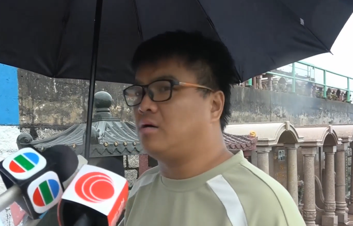 黃家駒墓碑遭破壞|深圳歌迷郝先生帶備鮮花和水果專程來到家駒的墳前,集合粉絲的心意拜祭悼念。(有線新聞畫面)