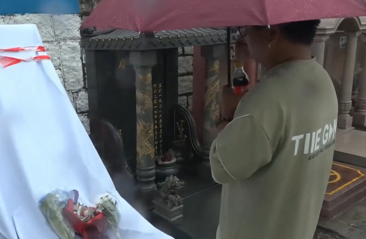 黃家駒墓碑遭破壞|深圳歌迷郝先生帶備鮮花和水果專程來到家駒的墳前,集合粉絲的心意拜祭悼念。(有線新聞畫面)