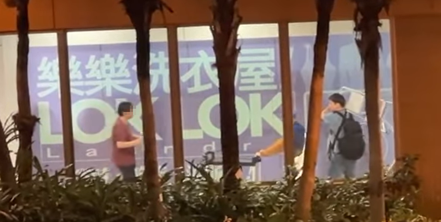 水泉澳快餐店斬人︱身穿紅色上衣的兇徒跟追上前的途人對峙,有人將收餐車推向持刀男阻止他走近,亦有人揮動一把梯打向兇徒(香港突發事故報料區fb)