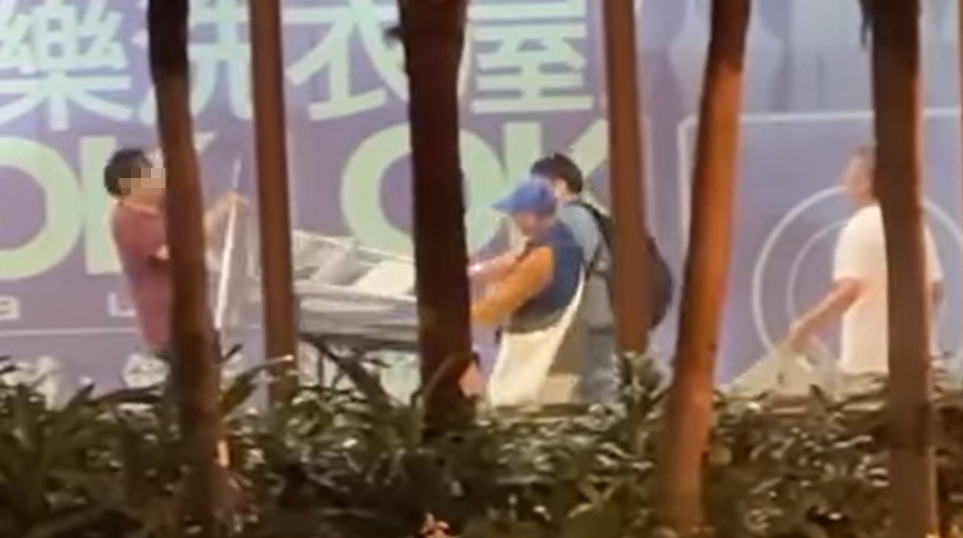 水泉澳快餐店斬人︱身穿紅色上衣的兇徒跟追上前的途人對峙,有人將收餐車推向持刀男阻止他走近,亦有人揮動一把梯打向兇徒(香港突發事故報料區fb)