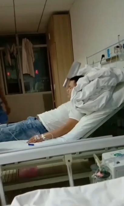 男子坐在醫院病床上,手插著針,那把刀仍卡在頭上。(微博)