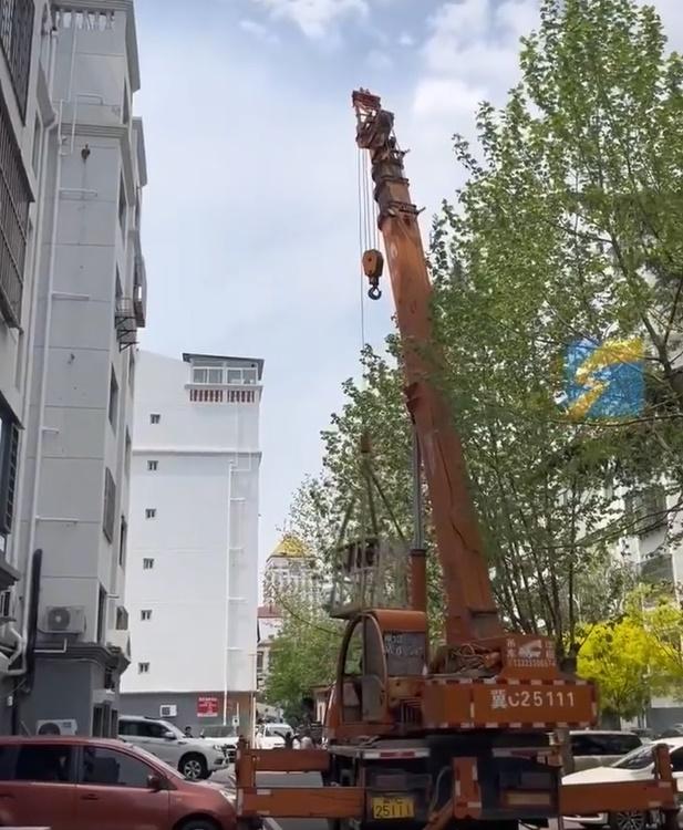 一輛吊車停在一幢樓高7層的大廈前。(微博)