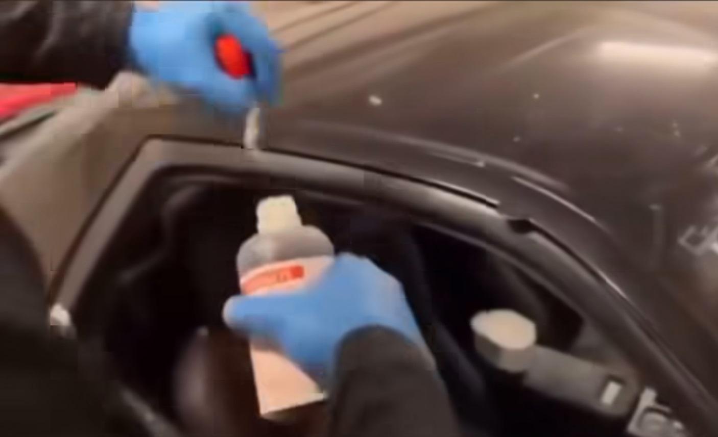 兩名黑衣男子向兩車的車廂淋潑疑似通渠水的腐蝕性液體。(網片截圖)