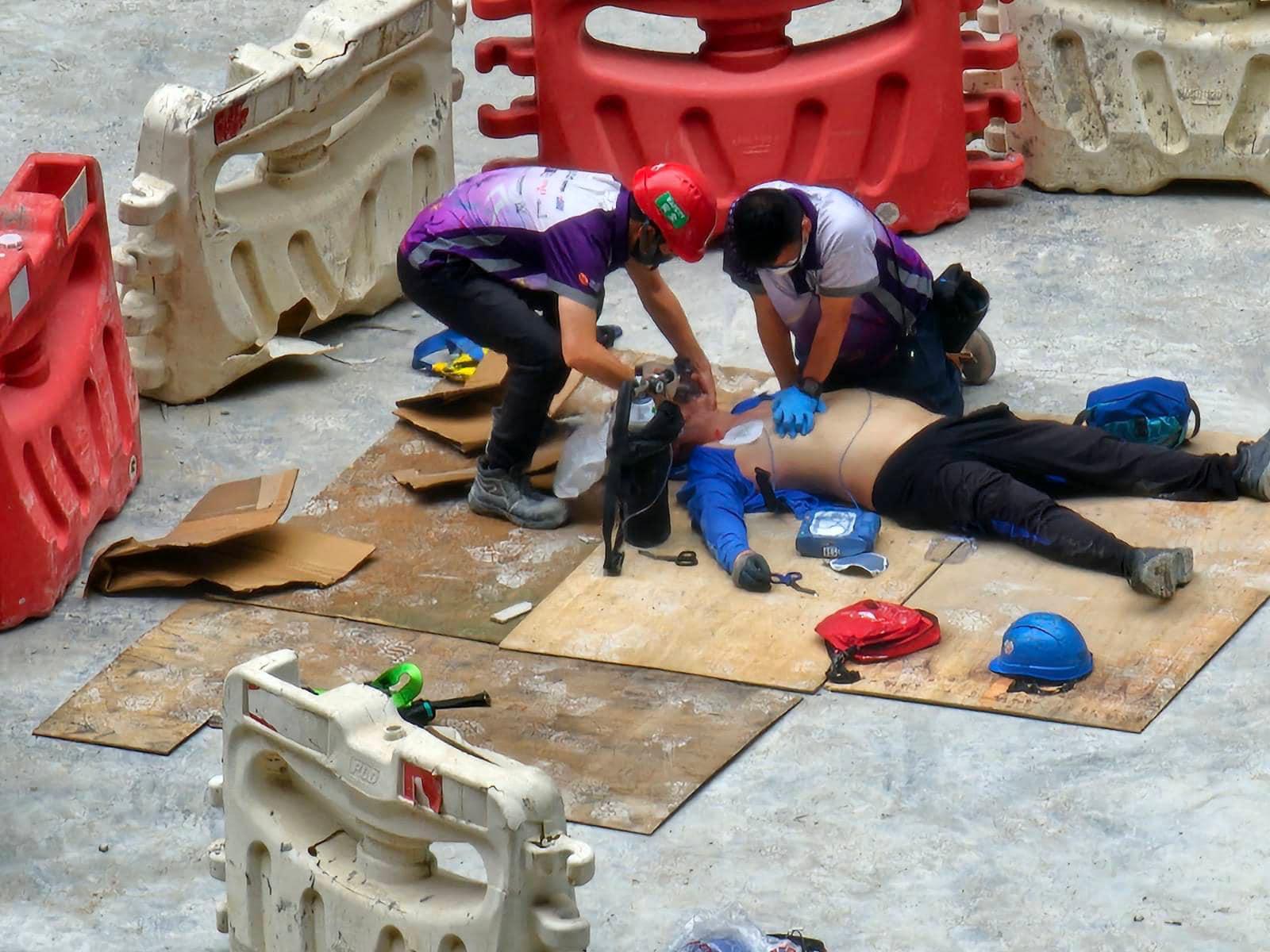 網上圖片顯示,現場有救護員為暈倒男工人進行急救。(香港突發事故報料區@fb圖)
