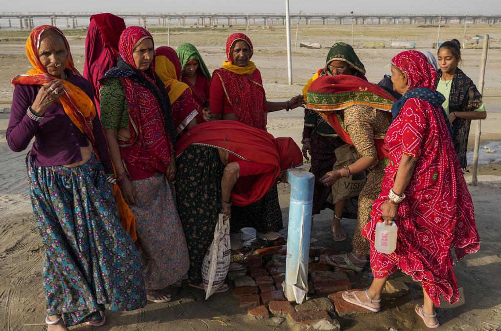 印度正遭受熱浪侵襲,一群婦女在恆河沿岸喝街上供水。(美聯社)