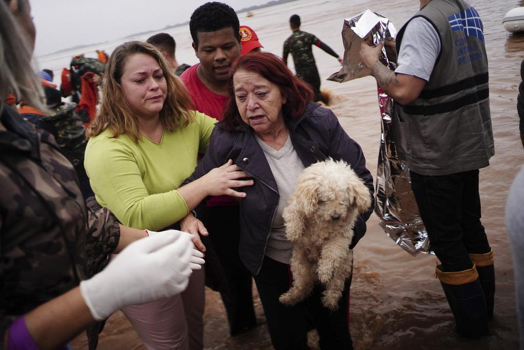 巴西南大河州水災災民帶著愛犬撤離家園。(美聯社)