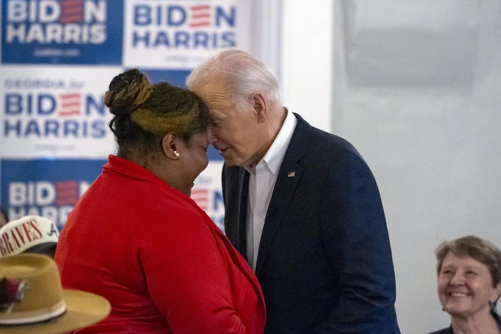 拜登在亞特蘭大一間由非裔人經營的餐廳與支持者會面,期間跟一名女士碰額頭招呼。(美聯社)