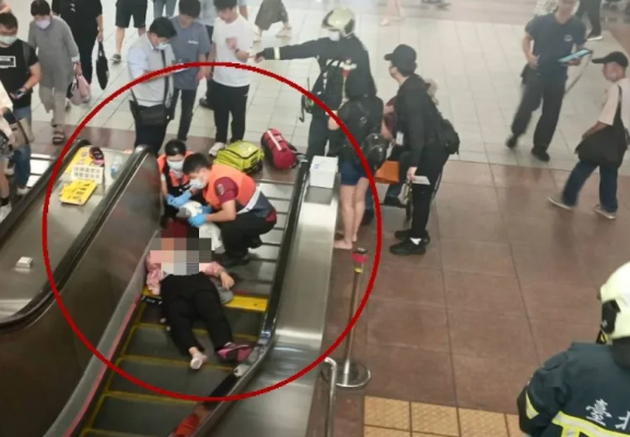 台灣台北市萬華龍山寺捷運站發生意外,一名84歲老翁搭手扶梯期間突身體不適往前跌,直接壓到4名香港遊客,眾人通通跌落地面,其中84歲婦人和女兒雙雙流血送院,幸沒生命危險。(TVBS電視畫面)