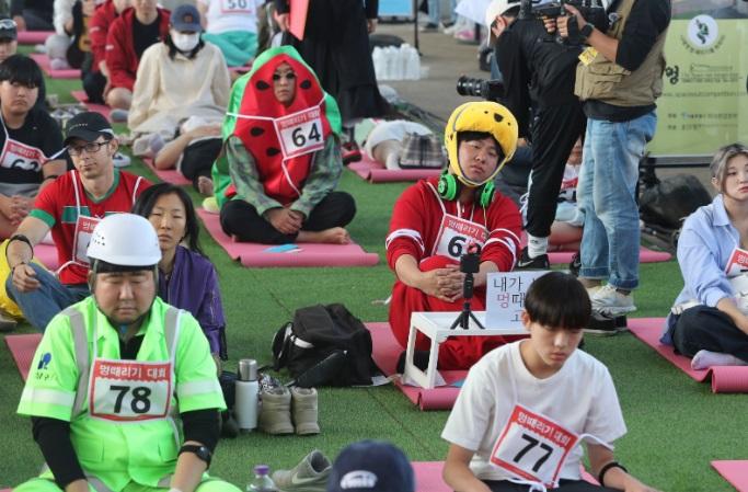 南韓年度發呆大賽在首爾盤浦漢江公園潛水橋邊舉行,參賽者以奇特造型吸引人。(新華社)