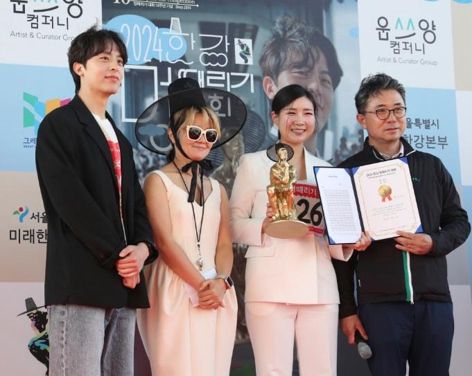 發呆大賽冠軍手捧小金人在賽後留影。(新華社)