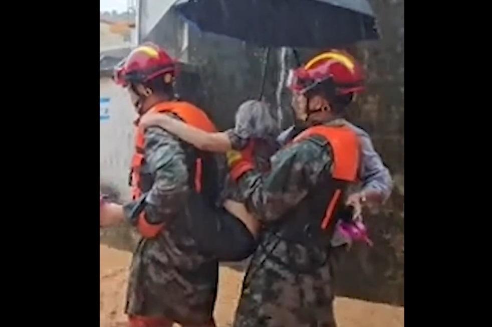 消防揹著受困98歲老婦離開住所。(互聯網)