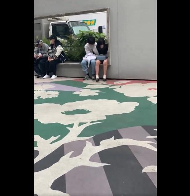 JR新宿車站東出口廣場,一對學生情侶疑在手淫。(互聯網)