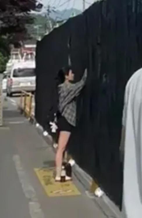 影片中,有女子在黑幕後方拍攝。(互聯網)