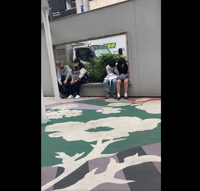 學生情侶疑似有愛情動作,坐在另一旁的男子張望。(互聯網)