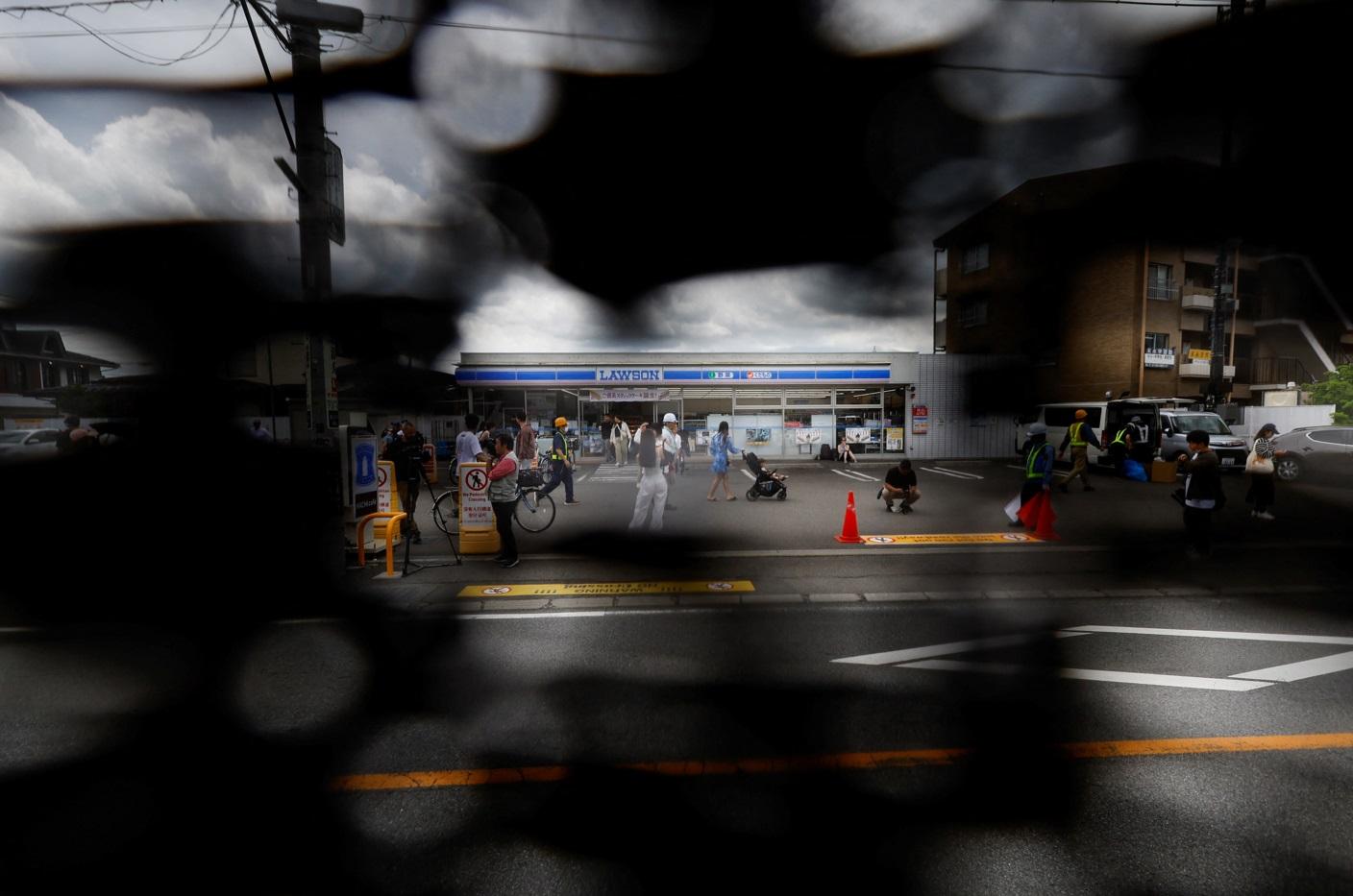 記者從黑幕的透光點拍攝LAWSON店。(路透社)