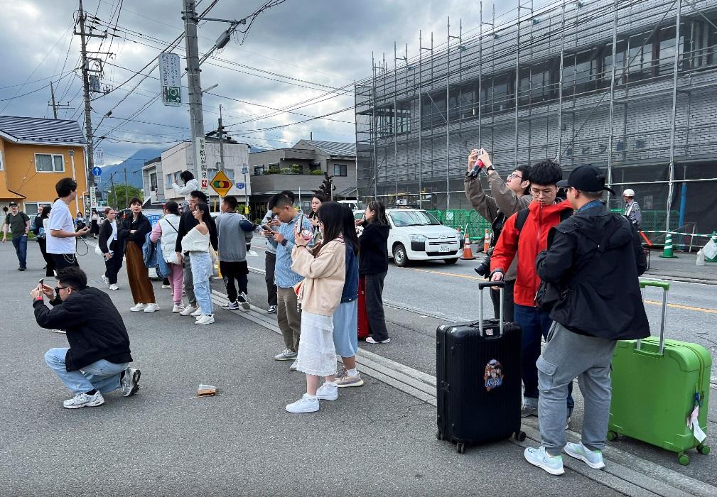 大批遊客聚集在LAWSON便利店前方位置拍攝富士山。(路透社)