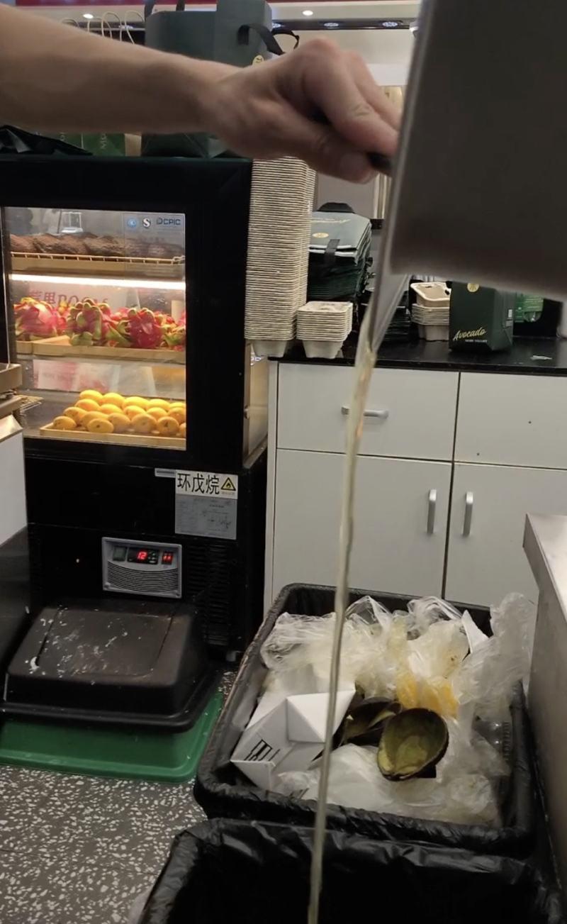 茉酸奶北京店將出水的鳳梨丁濾水後,準備隔夜繼續使用(新京報)