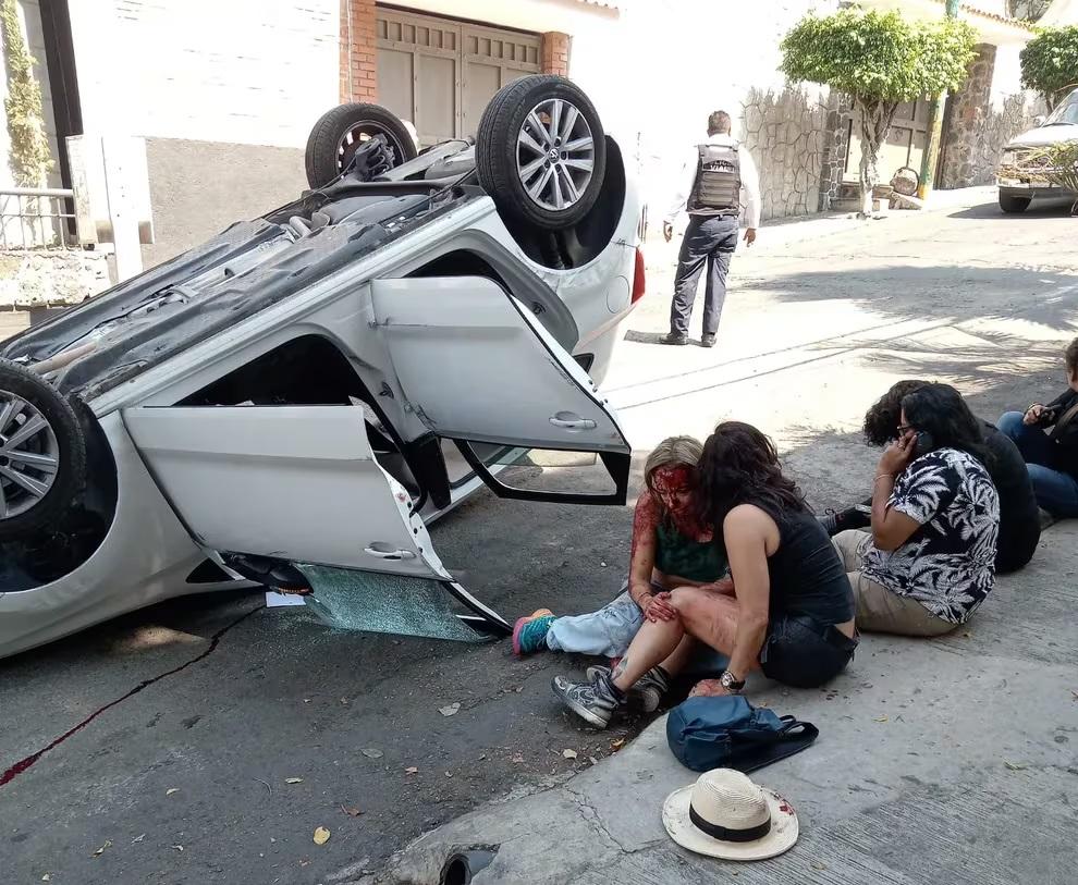 失控翻車後,5名女子坐在路邊等待救援,其中穿綠背心的女子滿身是血。(互聯網)