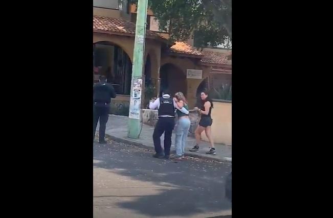 綠背心女子由警員攙扶,蹣跚走路,友人在旁陪同。(互聯網)