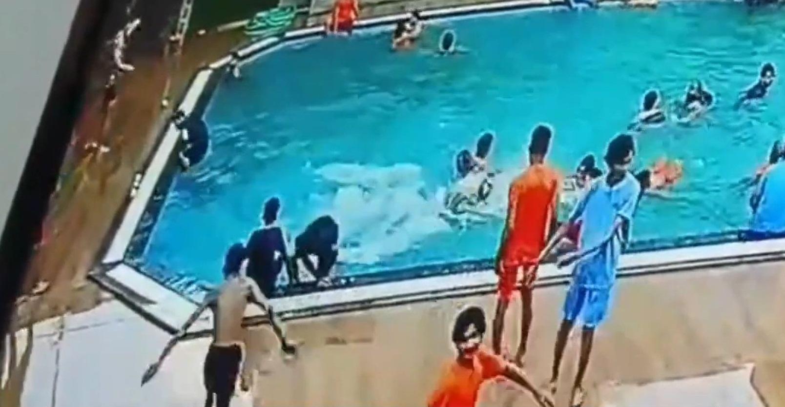 事發前,穿黑衣的蒂瓦里剛爬出泳池,其友人坐在池邊。(互聯網)