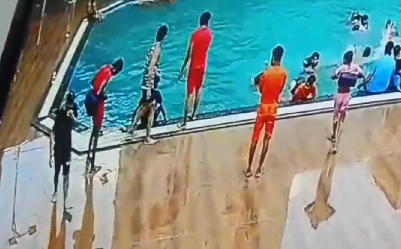 蒂瓦里跌進水裡。兩名穿紅衣的救生員站在池邊觀看,有人張望,但沒落水救人。(互聯網)