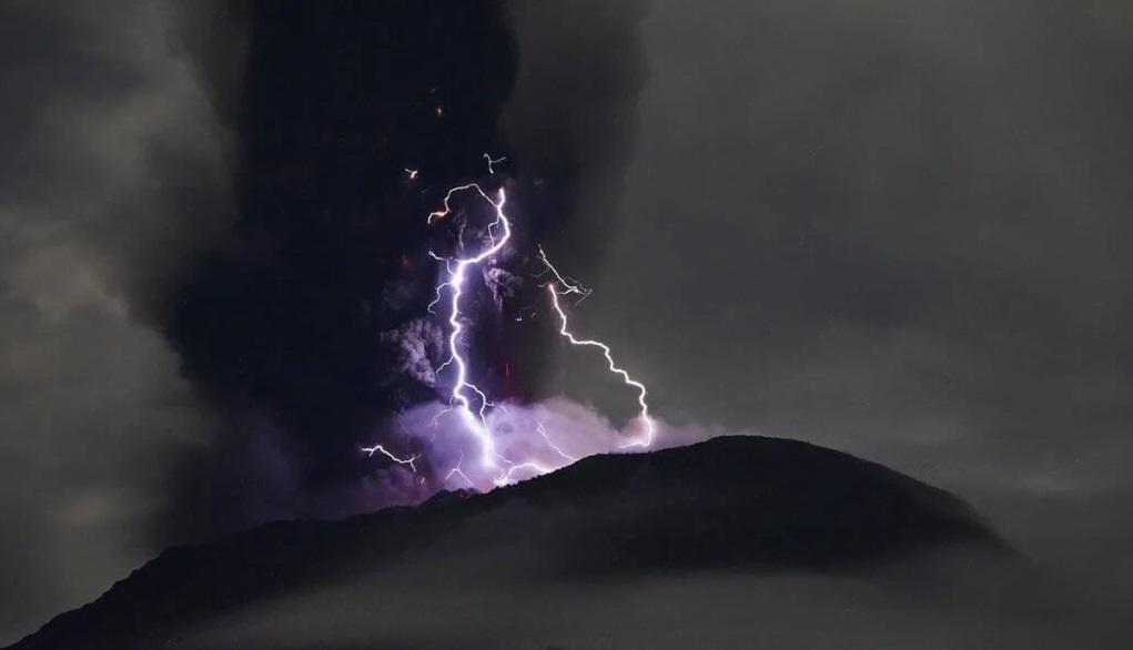 印尼伊布火山夾雜紫色閃電的巨大火山灰雲衝上半空。(互聯網)