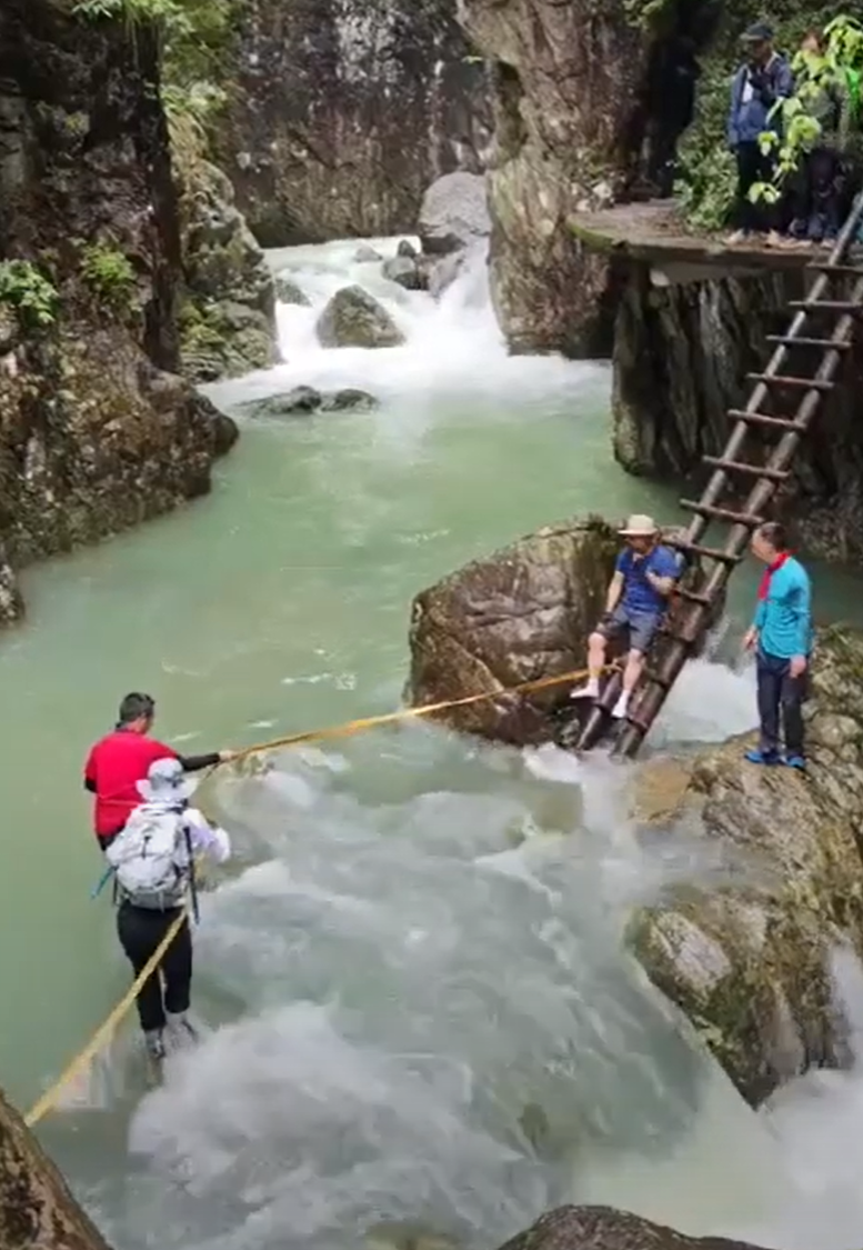 浙江台州石人峽景區有一男一女遊客用繩索橫渡峽谷溪流時,被水沖走(影片截圖)