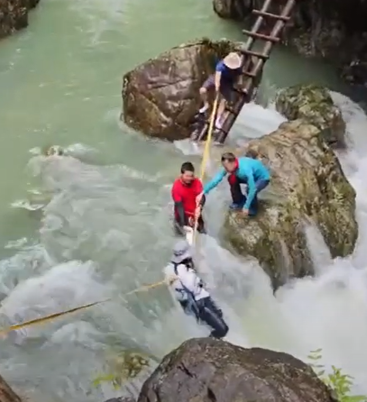 浙江台州石人峽景區有一男一女遊客用繩索橫渡峽谷溪流時,被水沖走(影片截圖)
