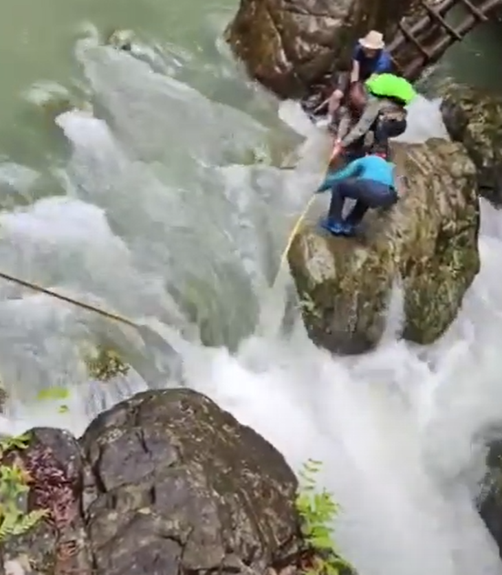 浙江台州石人峽景區有一男一女遊客用繩索橫渡峽谷溪流時,被水沖走(影片截圖)