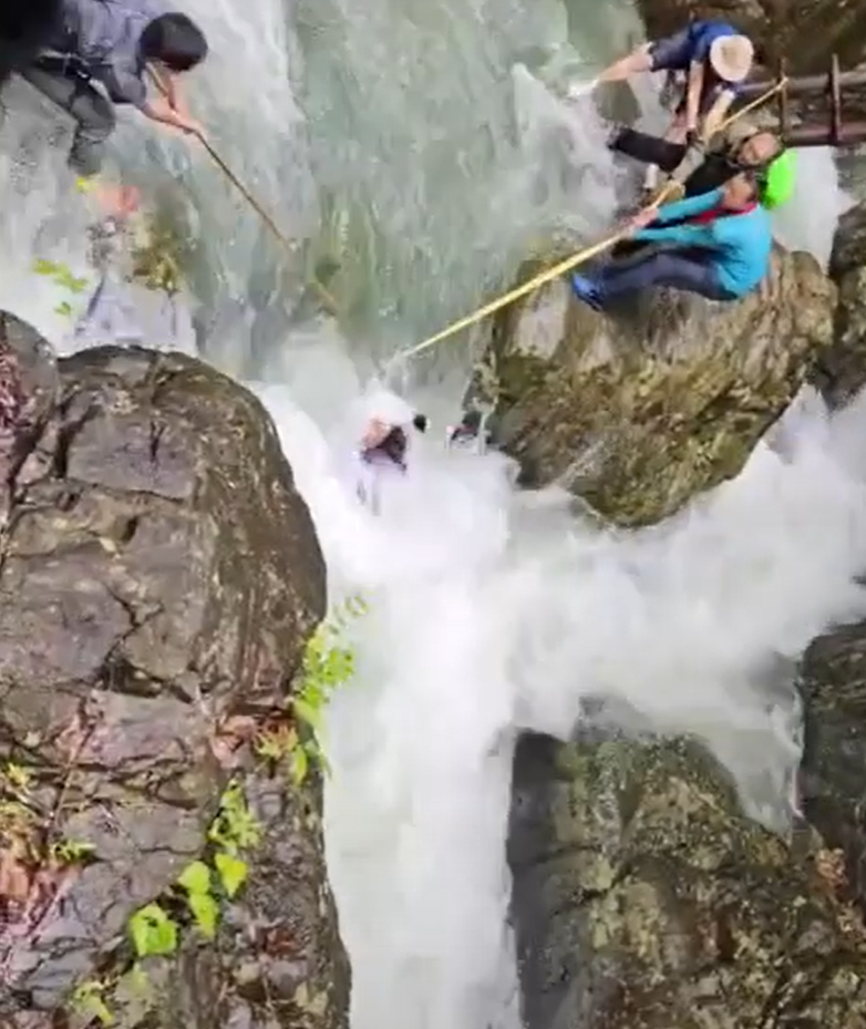 浙江台州石人峽景區有一男一女遊客用繩索橫渡峽谷溪流時,被水沖走(影片截圖)