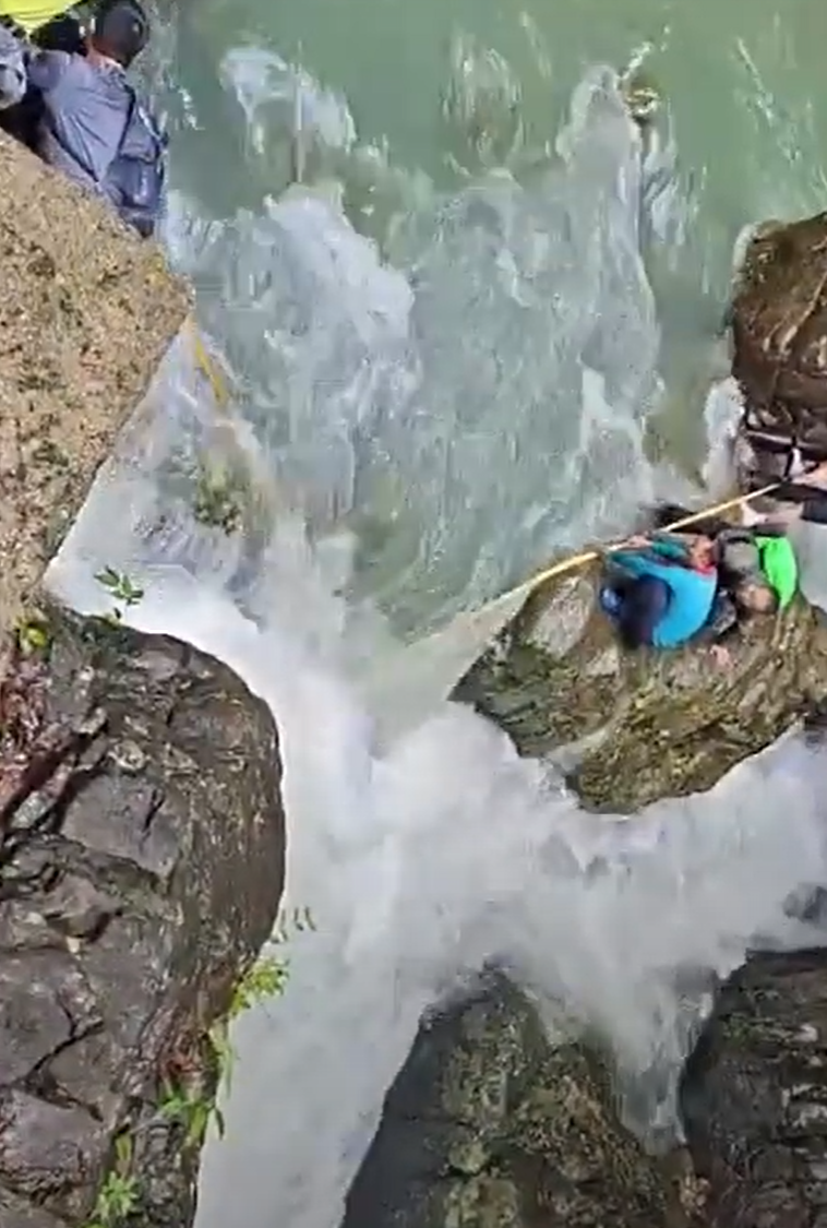 浙江台州石人峽景區有一男一女遊客用繩索橫渡峽谷溪流時,被水沖走(影片截圖)