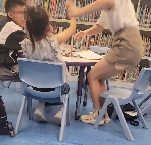一名母親懷疑在公共圖書館內因功課問題,多次掌摑及用粗言穢語責罵7歲女兒,及後在後樓梯繼續掌摑女兒(影片截圖)