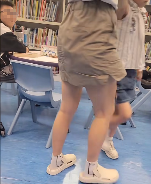 一名母親懷疑在公共圖書館內因功課問題,多次掌摑及用粗言穢語責罵7歲女兒,及後在後樓梯繼續掌摑女兒(影片截圖)