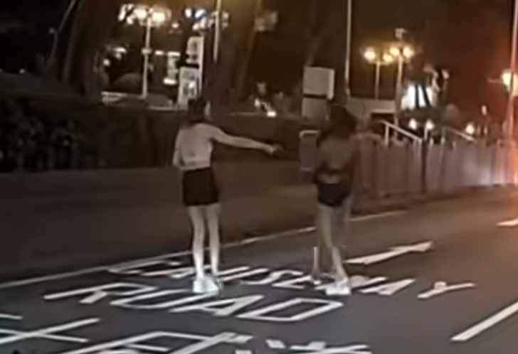 黑衣女先用手推撞的士司機,的士司機則用手擋格後退,她再上前起腳,對方亦及時避開。 FB「車camL(香港群組)」影片截圖