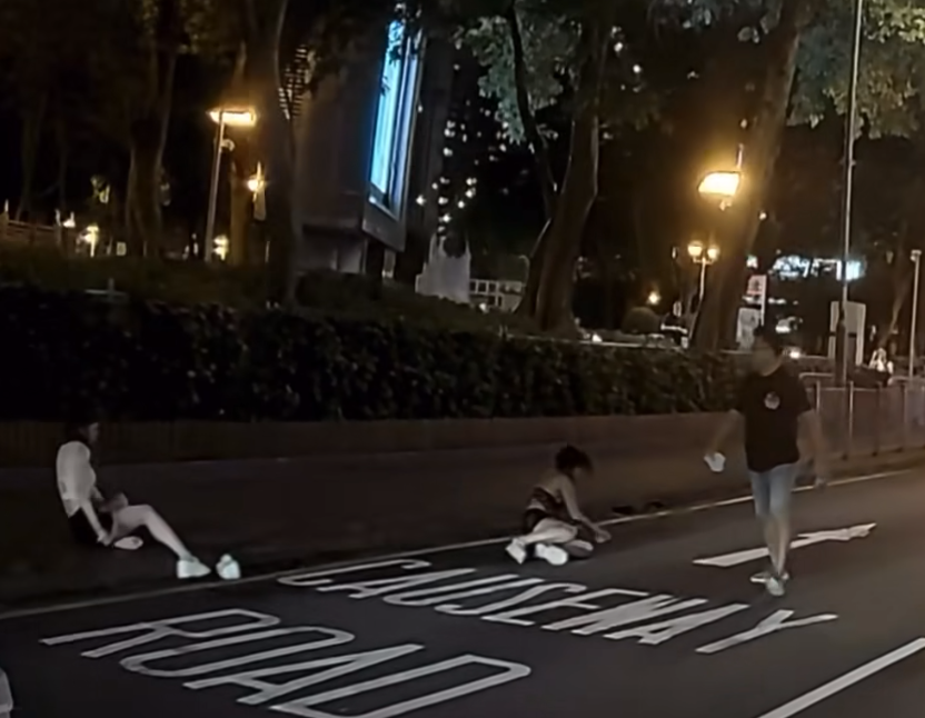 的士司機見兩女倒地後趁機步往的士方向,此時黑衣女起身跟隨,片段完結。 FB「車camL(香港群組)」影片截圖